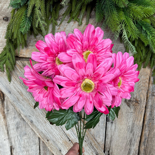 May include: A bouquet of pink artificial gerbera daisies with green leaves