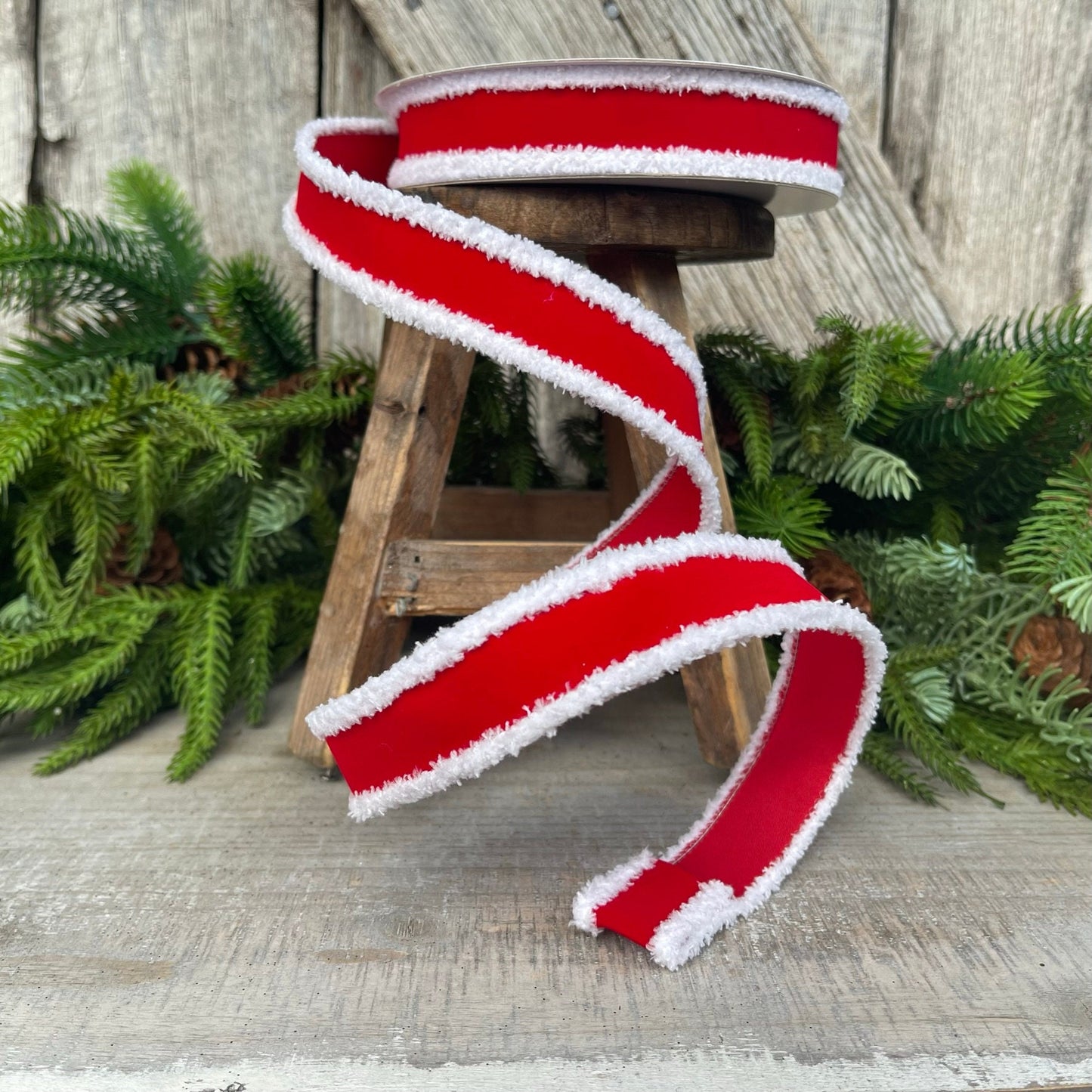 May include: Red velvet ribbon with white fuzzy trim. The ribbon is wrapped around a wooden stool.